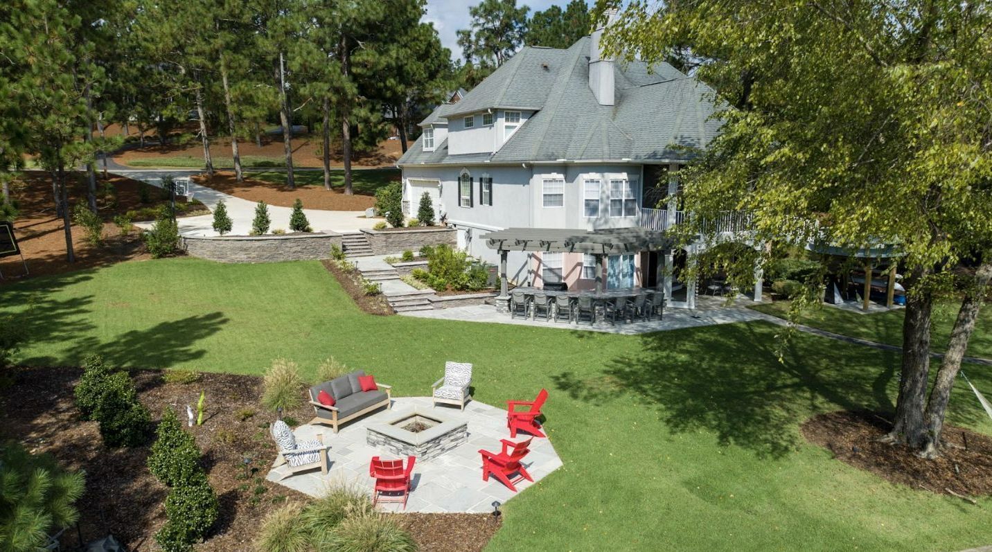 A nice view of a large house with a fire pit in the backyard