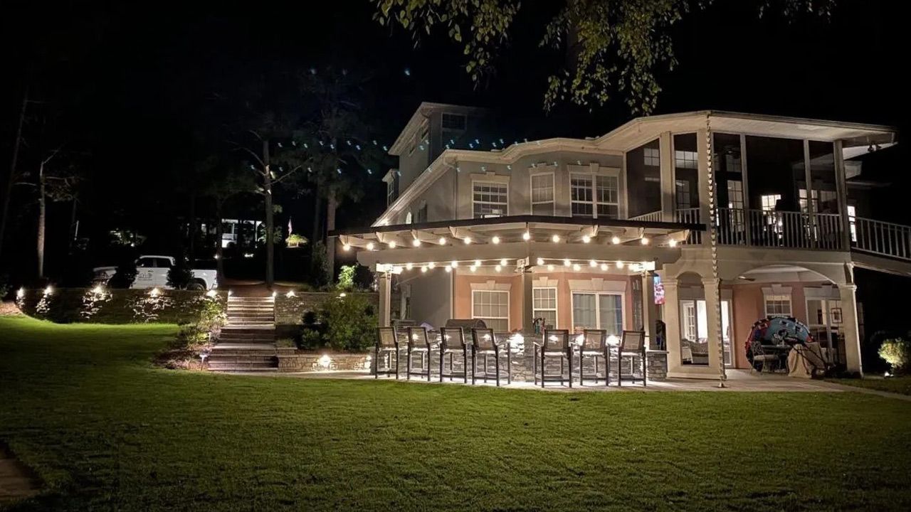 A large house with a lot of lights on it is lit up at night.