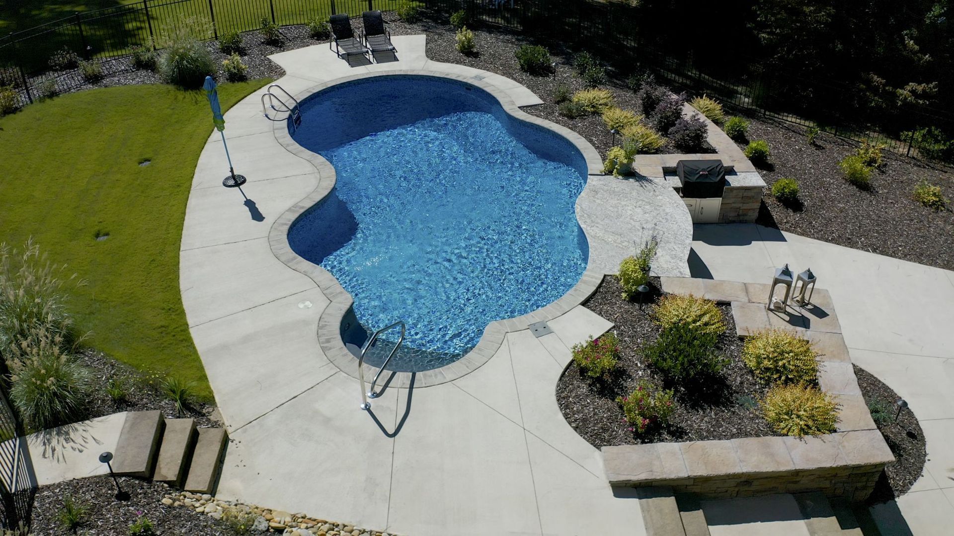 An aerial view of a large swimming pool in a backyard.