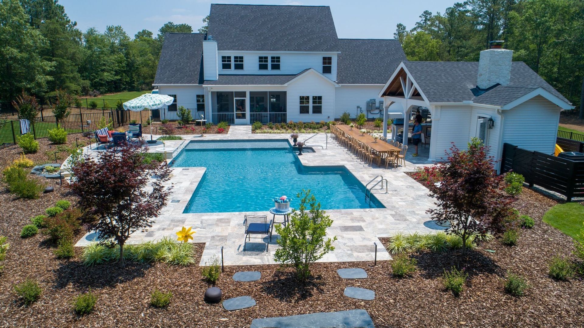 a large white house with a large swimming pool in front of it.