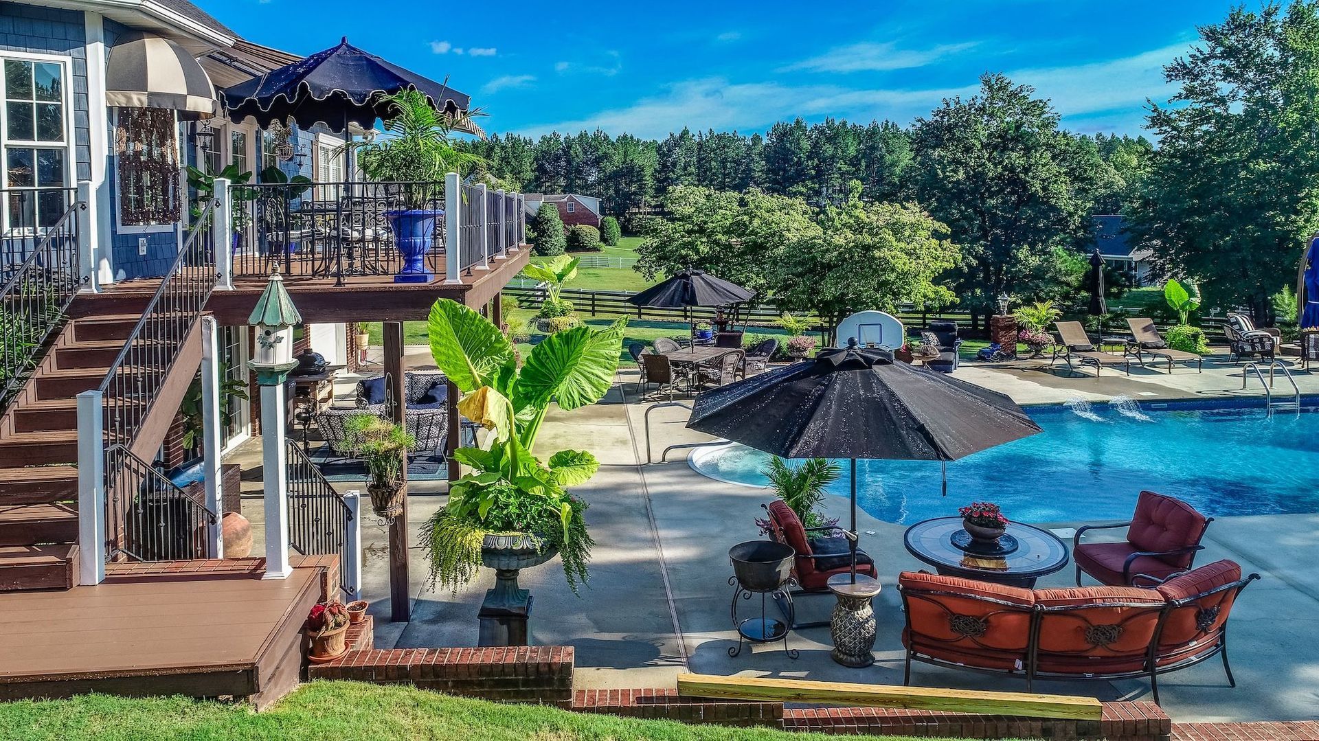There is a large swimming pool in the backyard of a house.