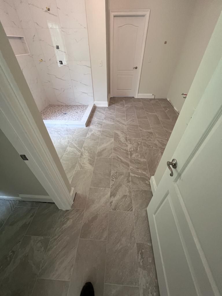 Empty hallway with carpeted stairs on the left and white doors along the right wall.