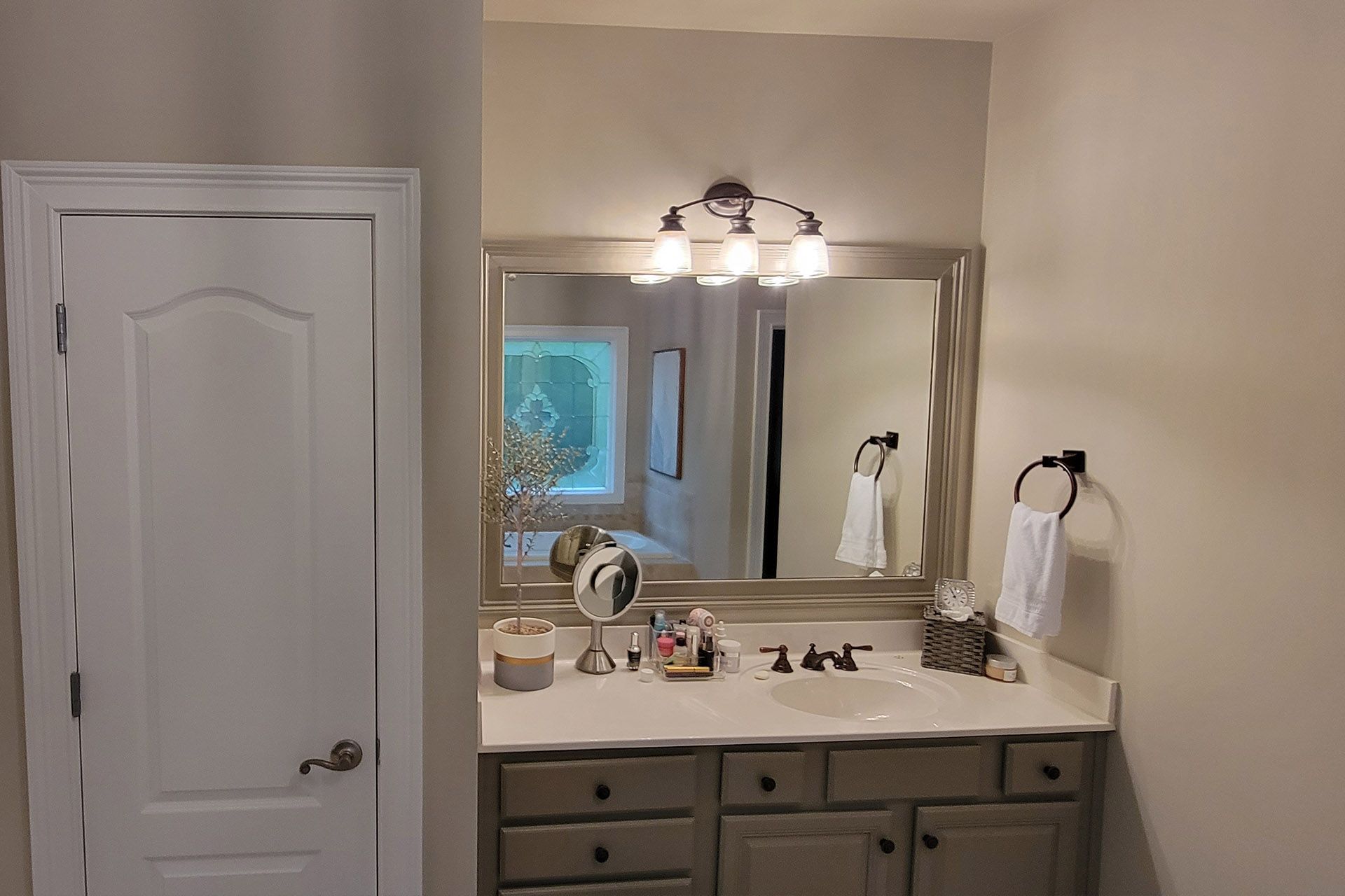 Bathroom renovation in progress with tiled walls, a window, and tools on the floor.