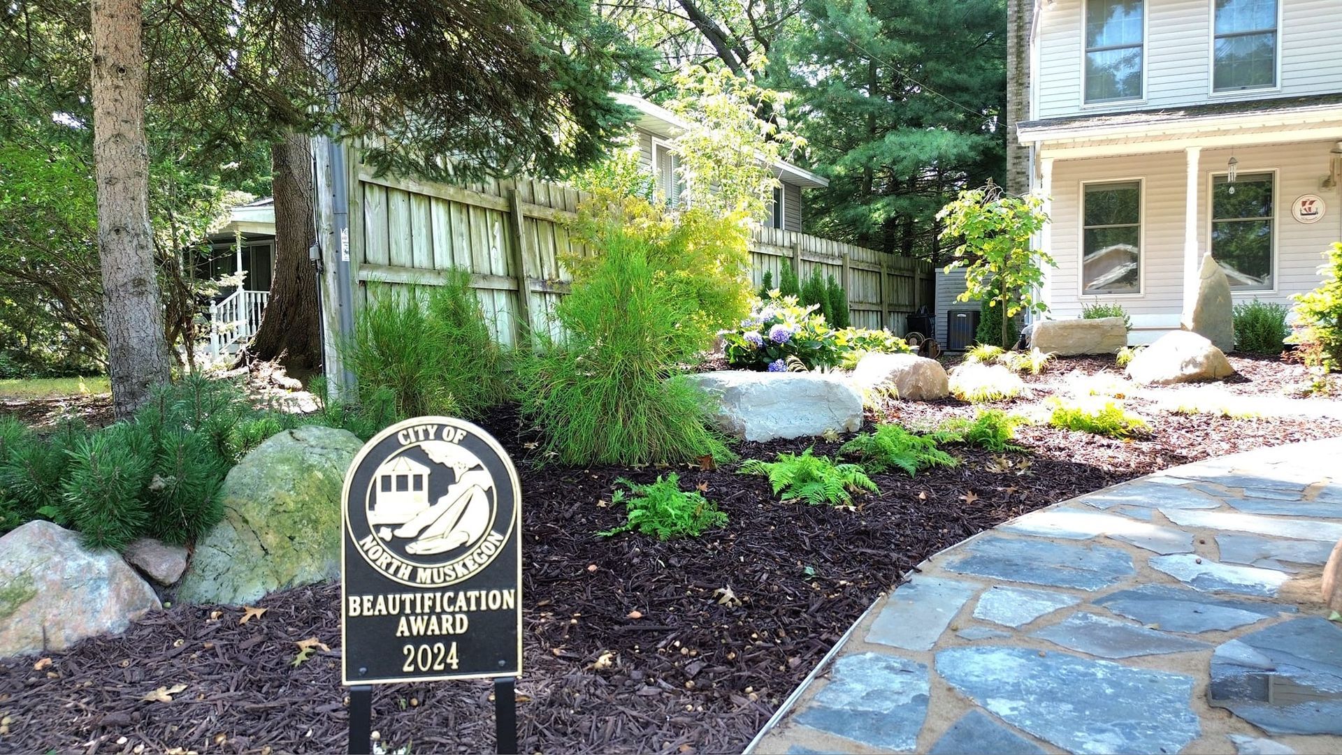 Sign for the Constitution Hotel with a pathway and garden in front of a building.