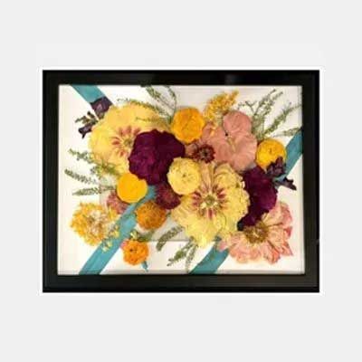 Framed floral arrangement with yellow, pink, burgundy, and orange flowers on a white background.