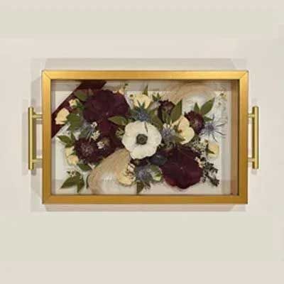 Framed floral arrangement with burgundy and white blooms, gold frame with handles.