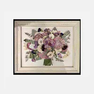 Dried flower bouquet framed in white with a black background. Purple and white flowers.