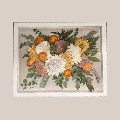 Framed pressed floral bouquet in yellow, orange, white, and purple.