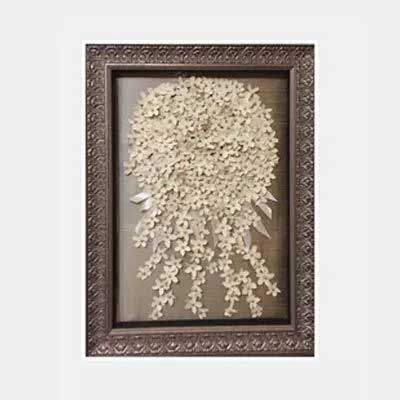 Brown framed artwork; paper flower bouquet with trailing blossoms.