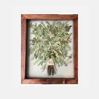 Dried floral bouquet framed in rustic brown wood.