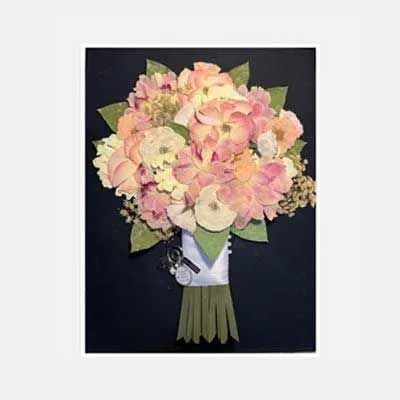 A bouquet of pink and yellow flowers tied with a white ribbon against a black background.