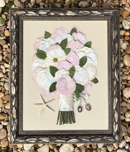Framed art: preserved wedding bouquet with pink, white flowers, starfish, and jewels.