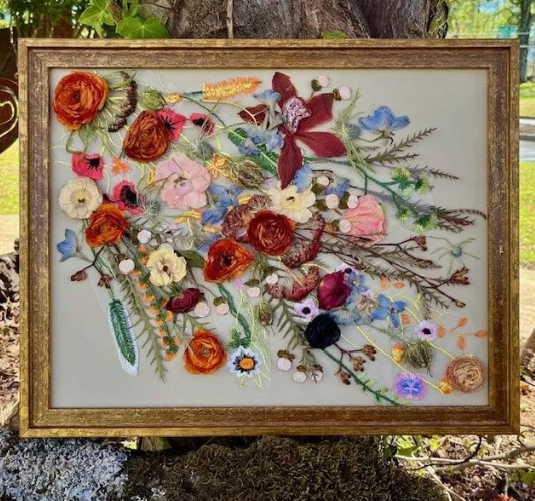 Framed floral artwork with pressed flowers in golds, reds, blues, and greens.