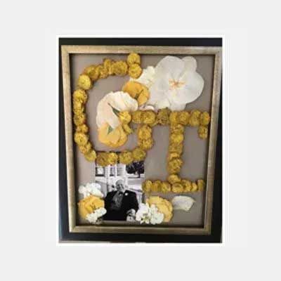 Framed memorial art with dried flowers spelling 