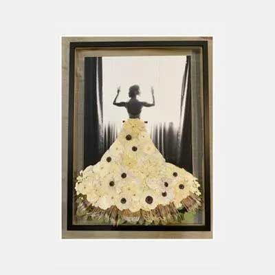 A framed artwork features a woman's silhouette raising her arms, wearing a skirt made of light-colored flowers.