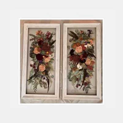 Two framed floral arrangements with dried flowers in shades of red, peach, and green.