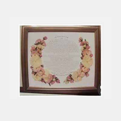 Framed document with floral border, likely a certificate.