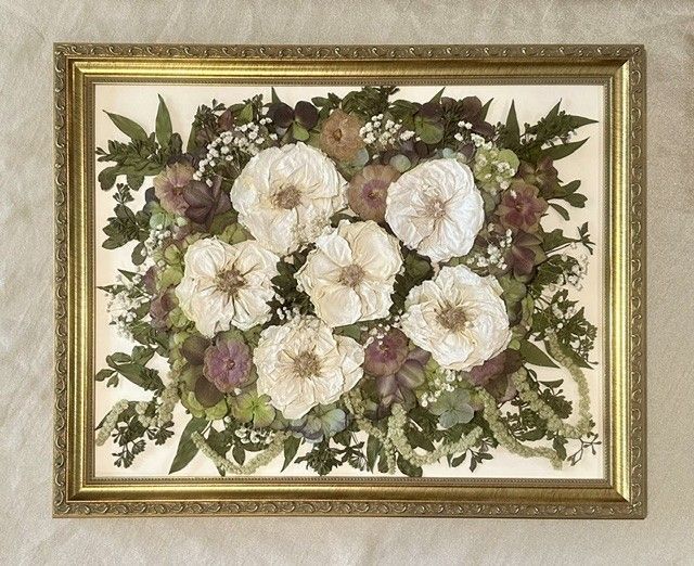 Framed floral wall art with white and purple flowers on a cream background.