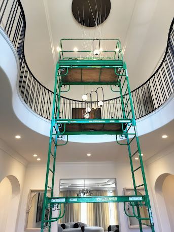 A green scaffolding is in the middle of a living room.