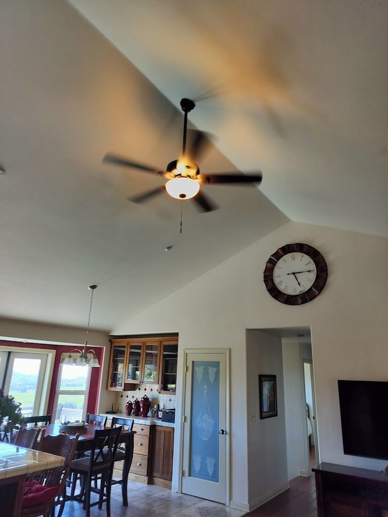 A living room with a ceiling fan and a clock on the wall.