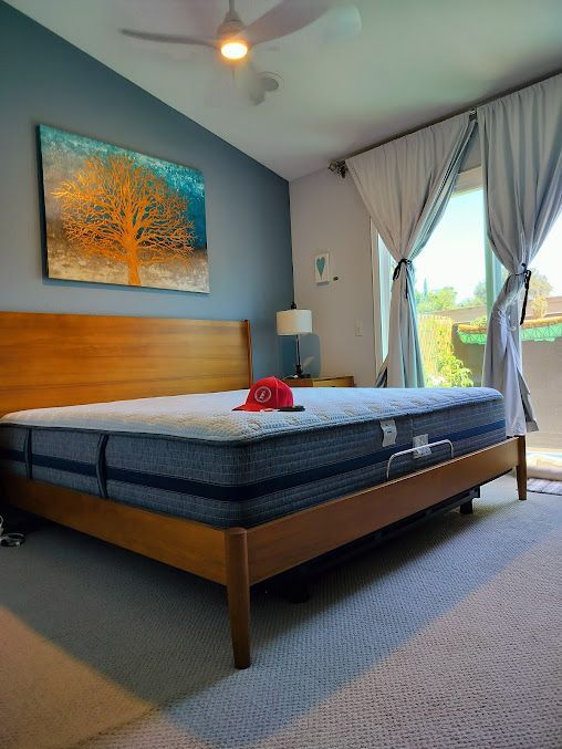 A bedroom with a bed and a painting on the wall.