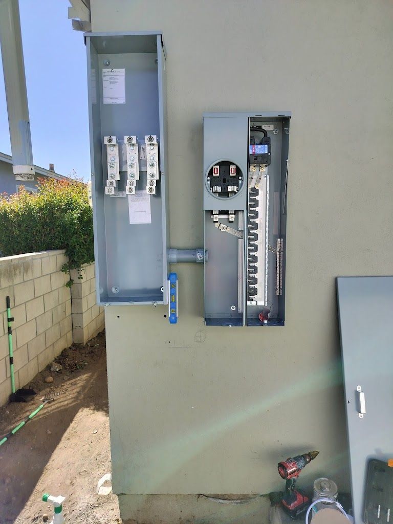 A electrical box is being installed on the side of a building.