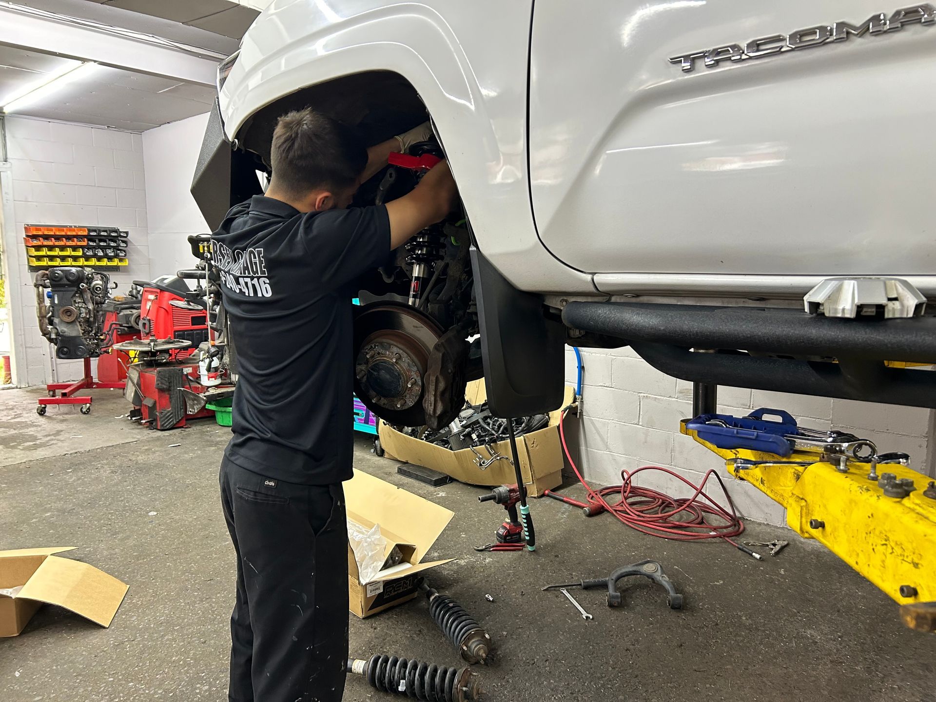 A man is working on a white truck in a garage.