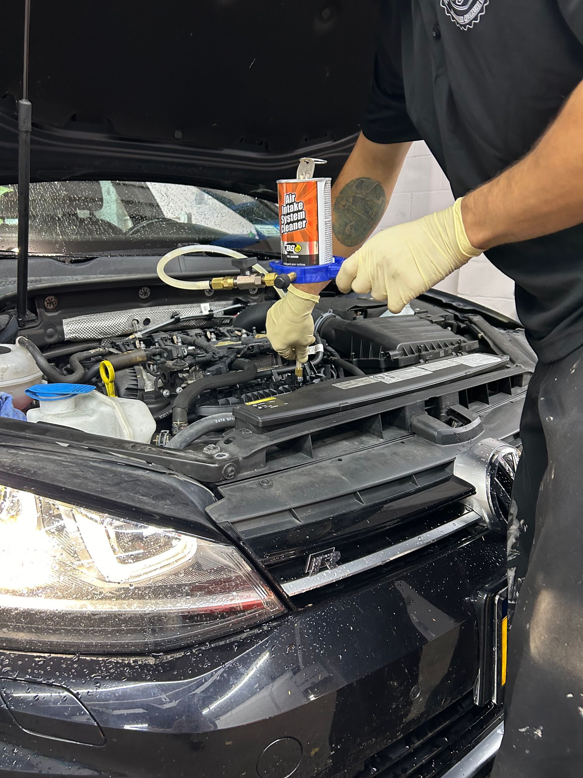A man is working on the engine of a car.