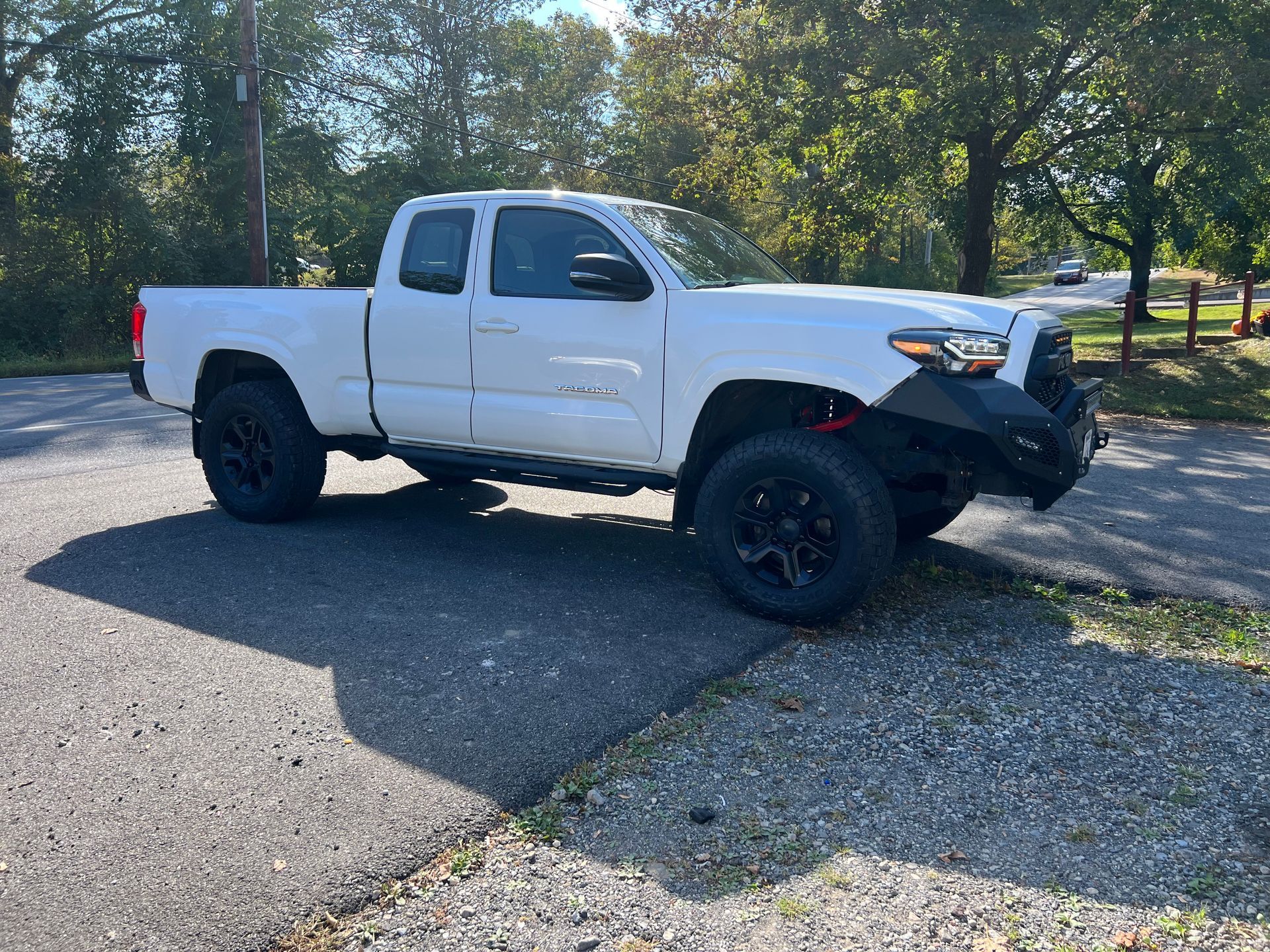 A white truck is parked on the side of the road.