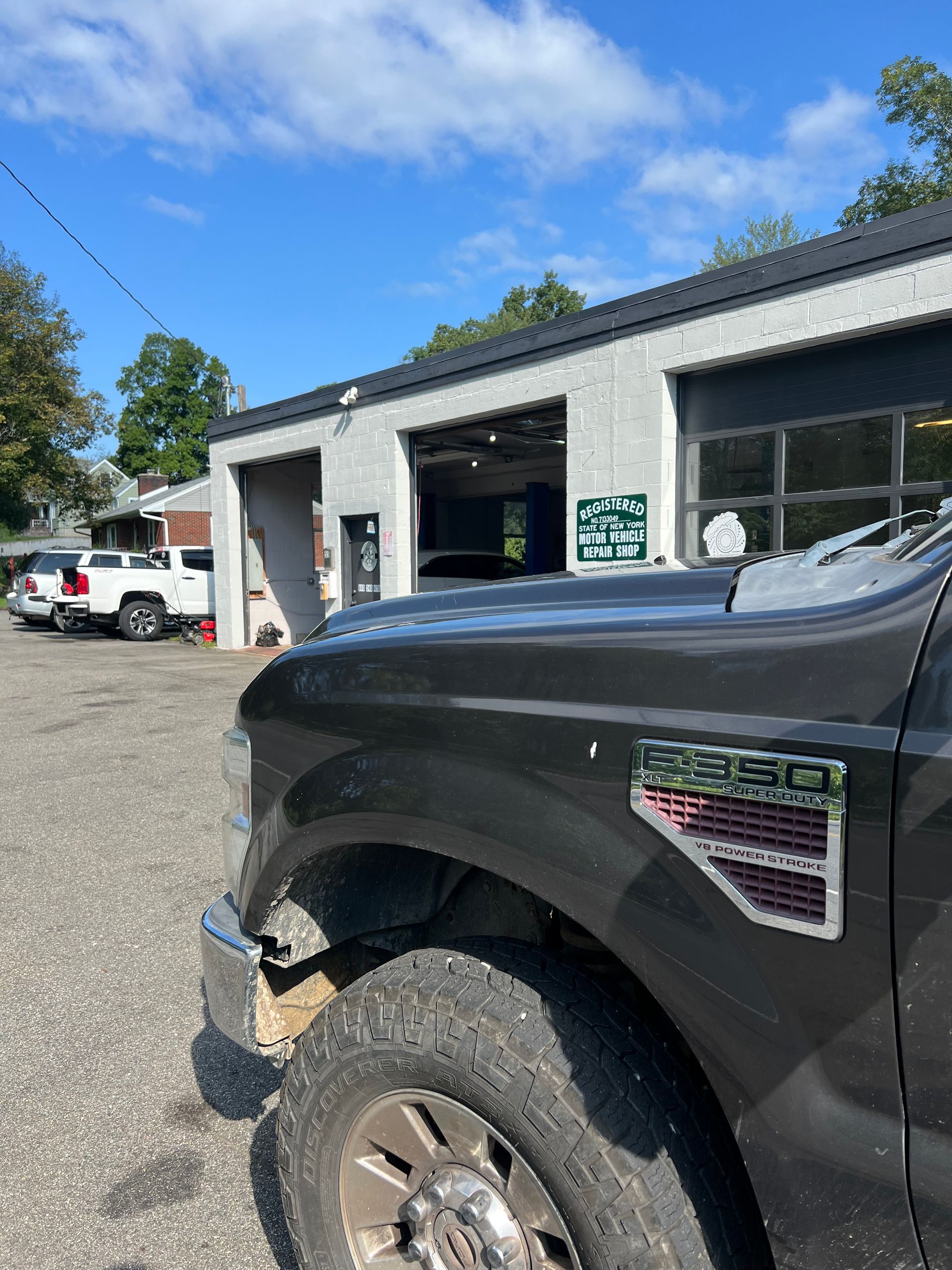 A black truck is parked in front of a garage.