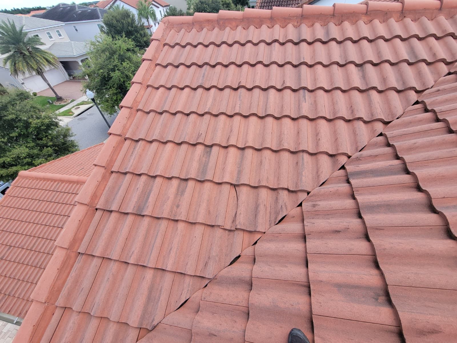 Terracotta roof tiles on a house, with a roof repair seam visible near the ridge.