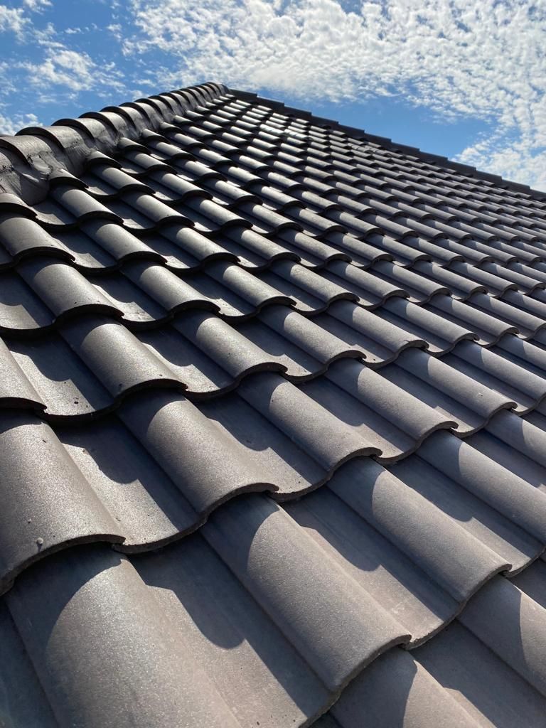 Gray tiled roof viewed from below under a clear blue sky