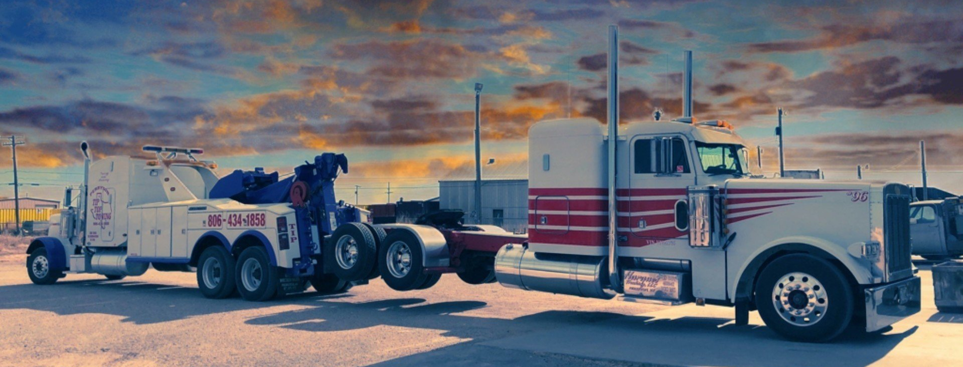 A red and white tow truck is parked on the side of the road.