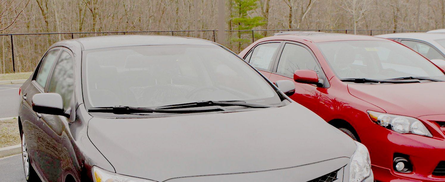 Three cars are parked next to each other in a parking lot.