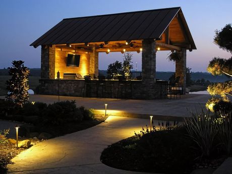 A gazebo is lit up at night with a walkway leading to it