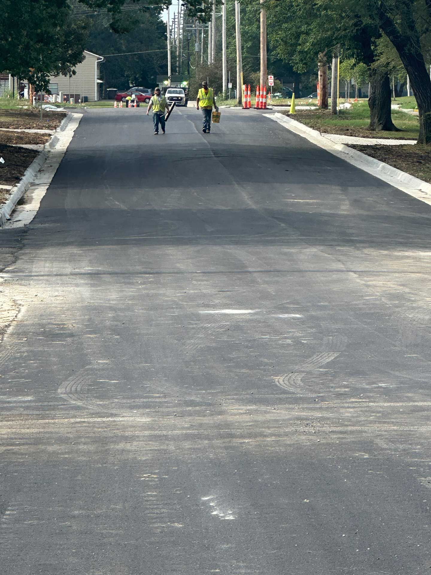 workers are walking down a concrete street
