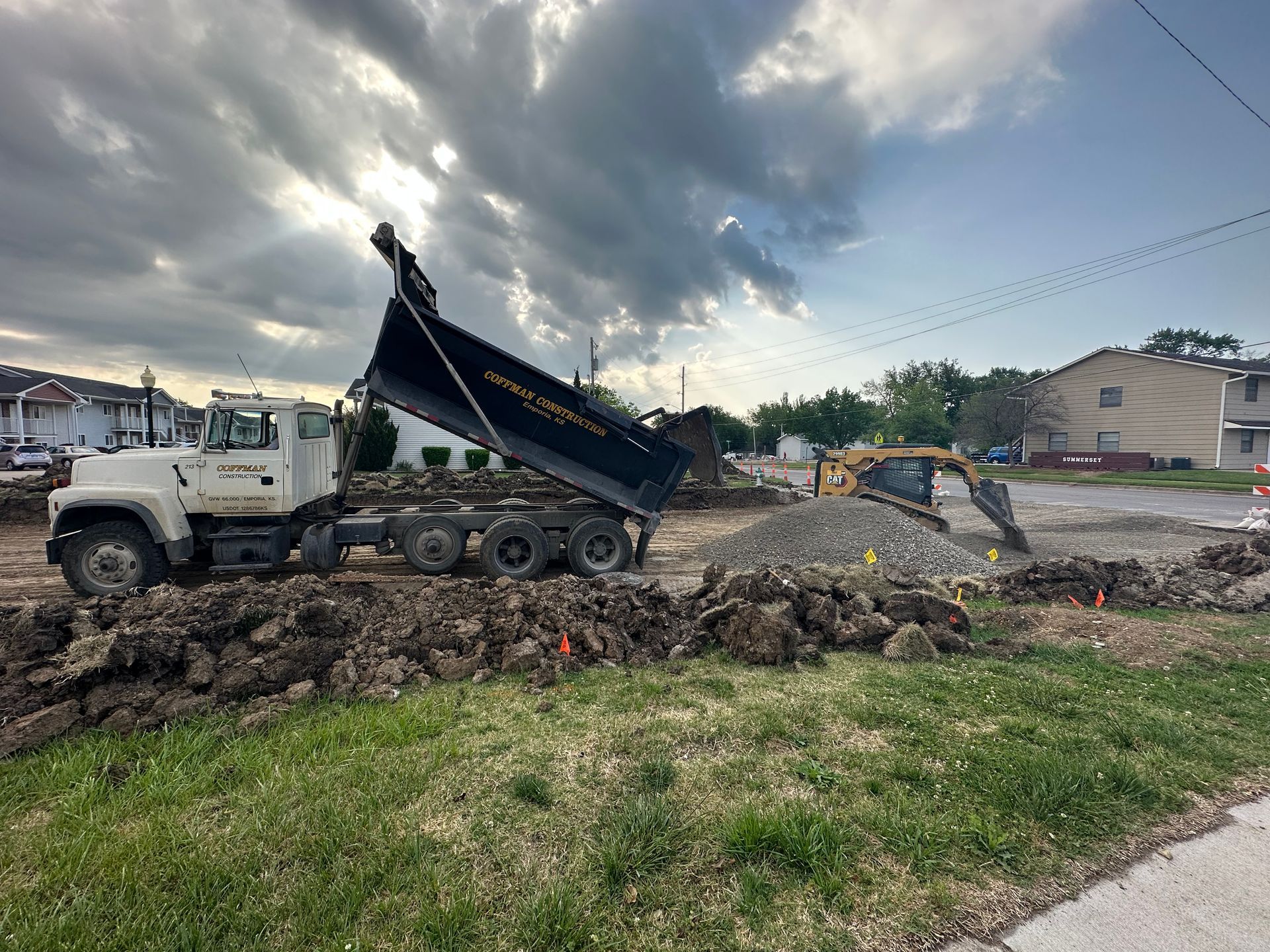 a dump truck is dumping dirt on a construction site