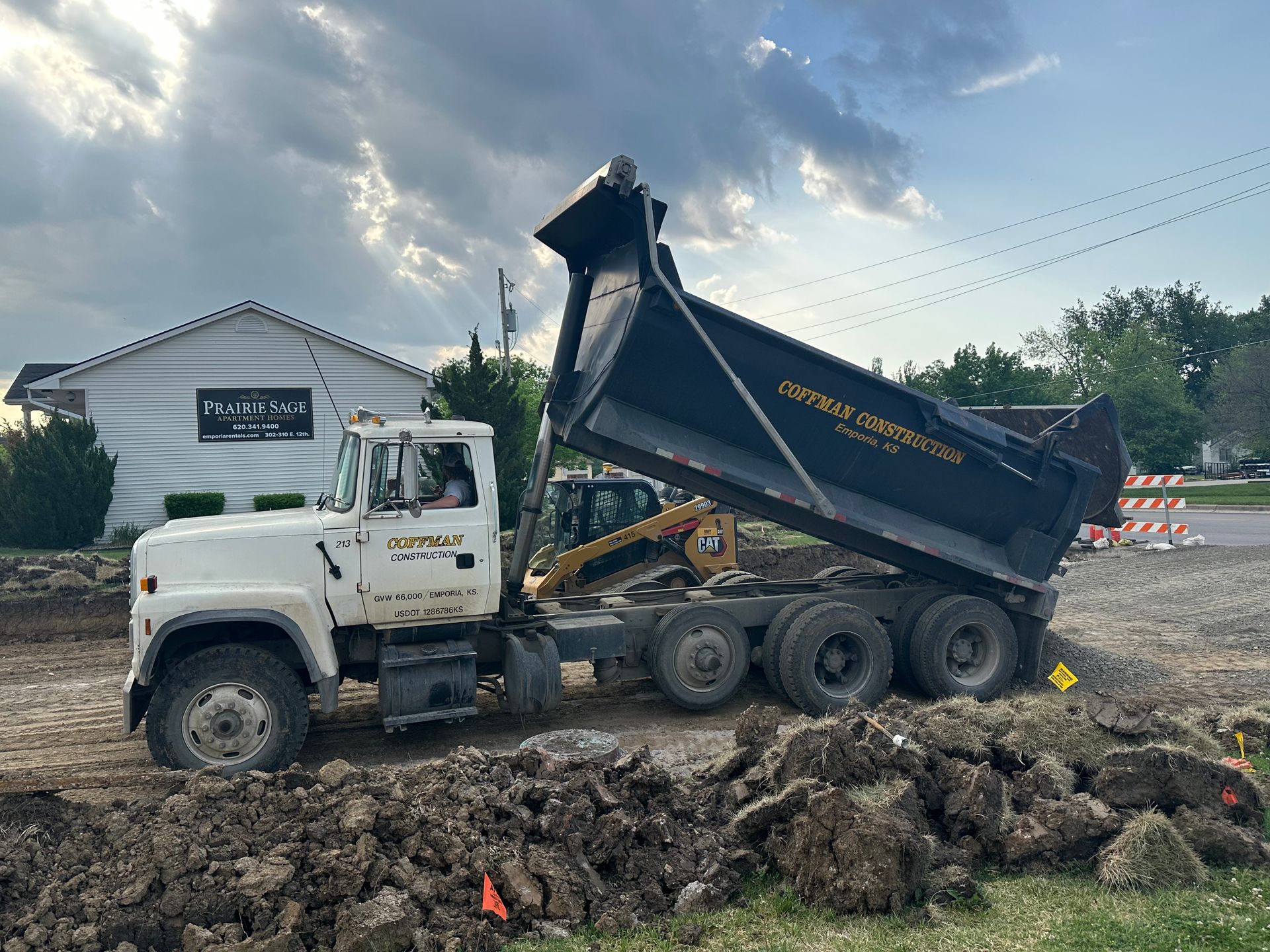 a dump truck is dumping dirt on a construction site