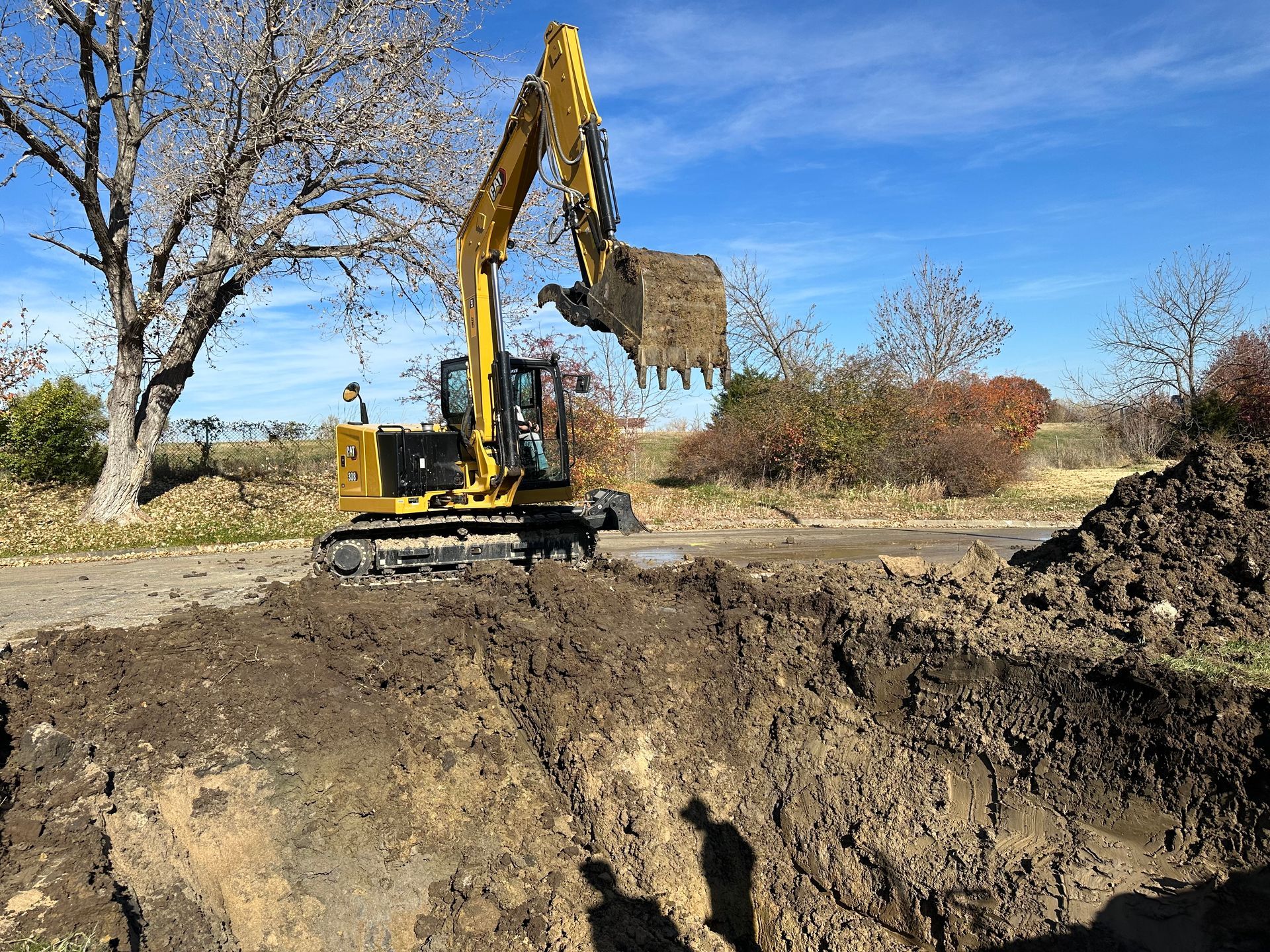 a yellow excavator is digging a hole in the dirt