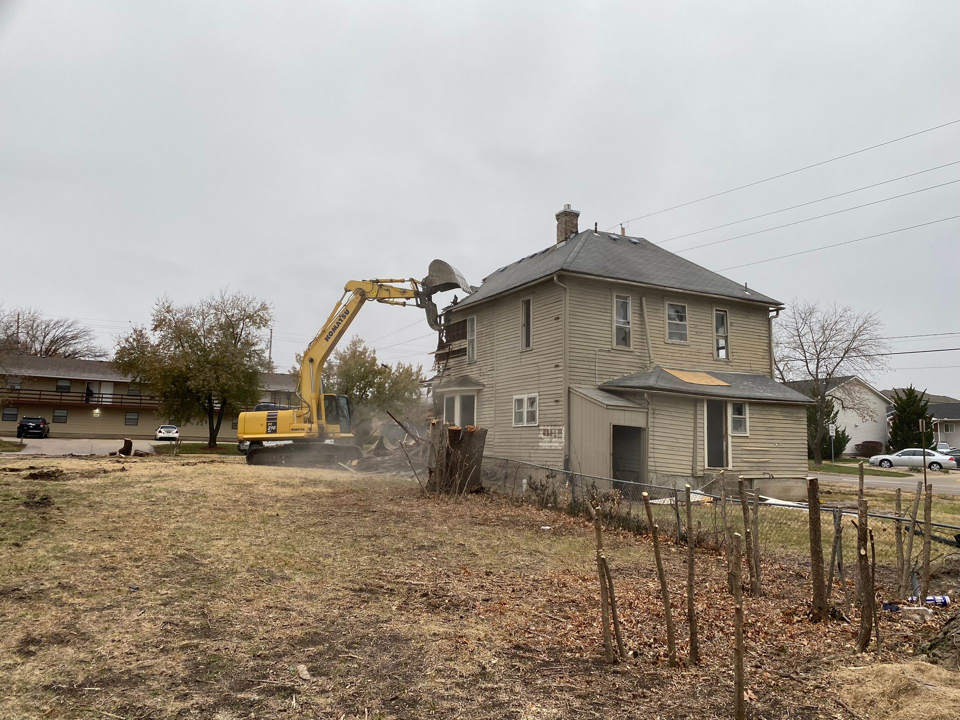 a house is being demolished by a yellow excavator
