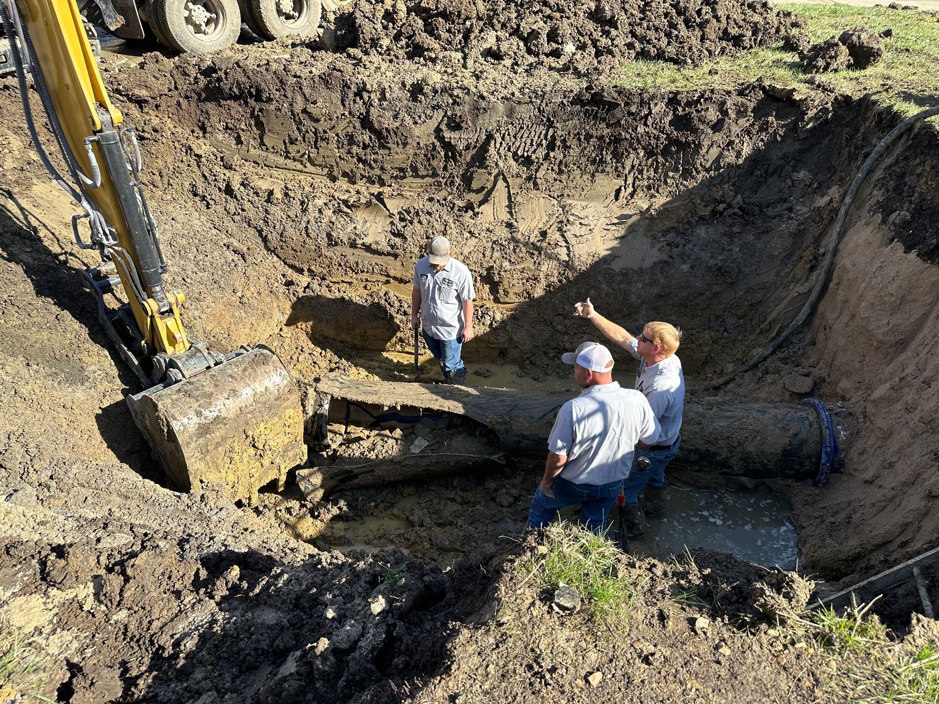 a group of men are standing in a large hole in the ground