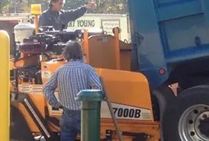 A man is standing next to a truck that says 7000b on it.