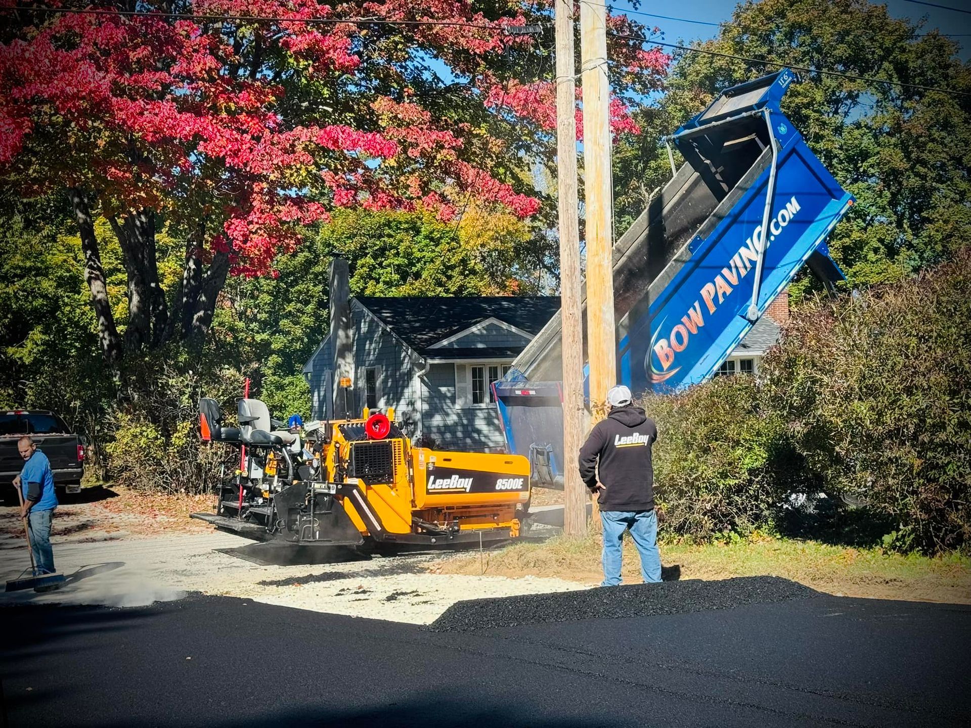Paving a driveway leading to a large house.