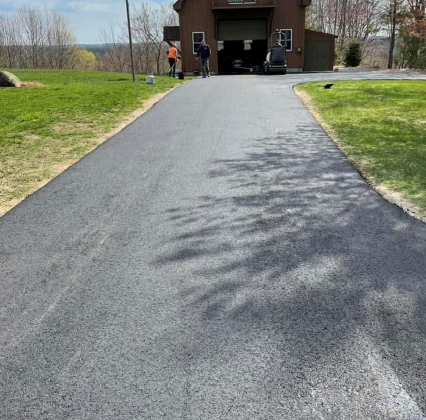 A man is walking down a driveway towards a garage.