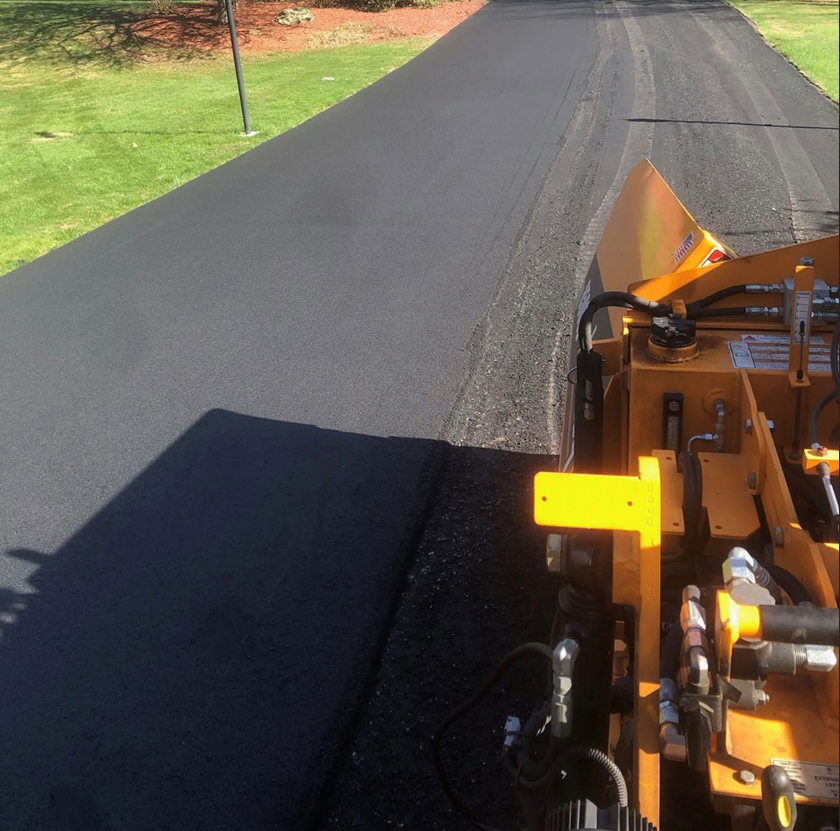 A yellow machine is sitting on the side of a road