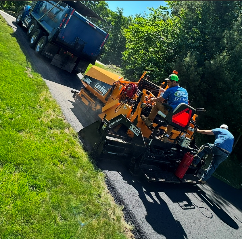 A man sitting on a machine that says asphalt on it