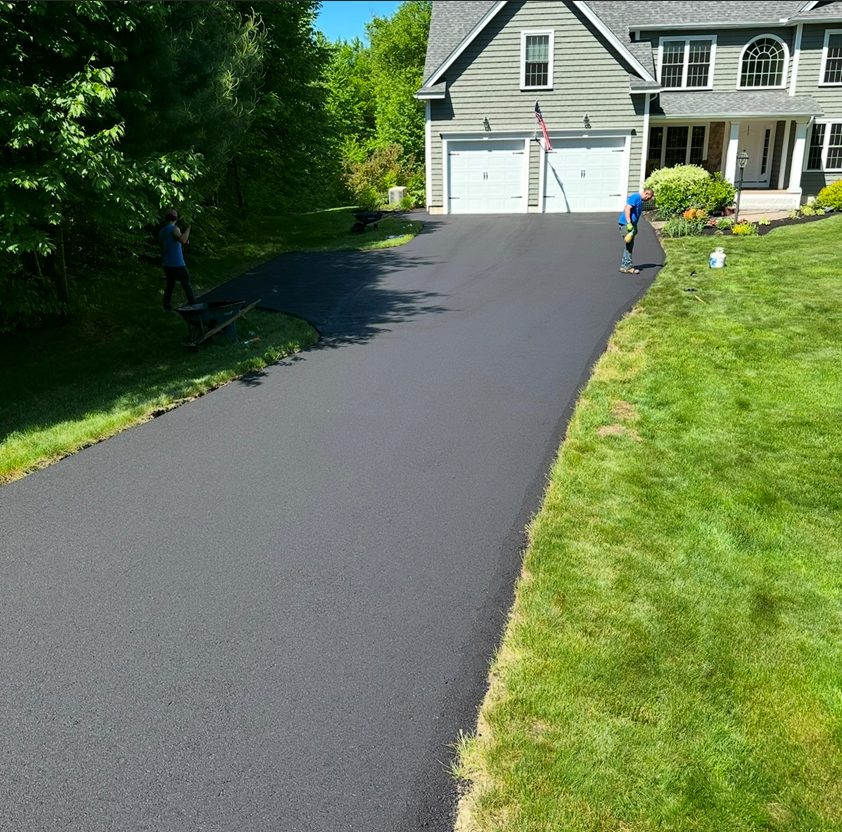 A man is standing on the side of a driveway next to a house