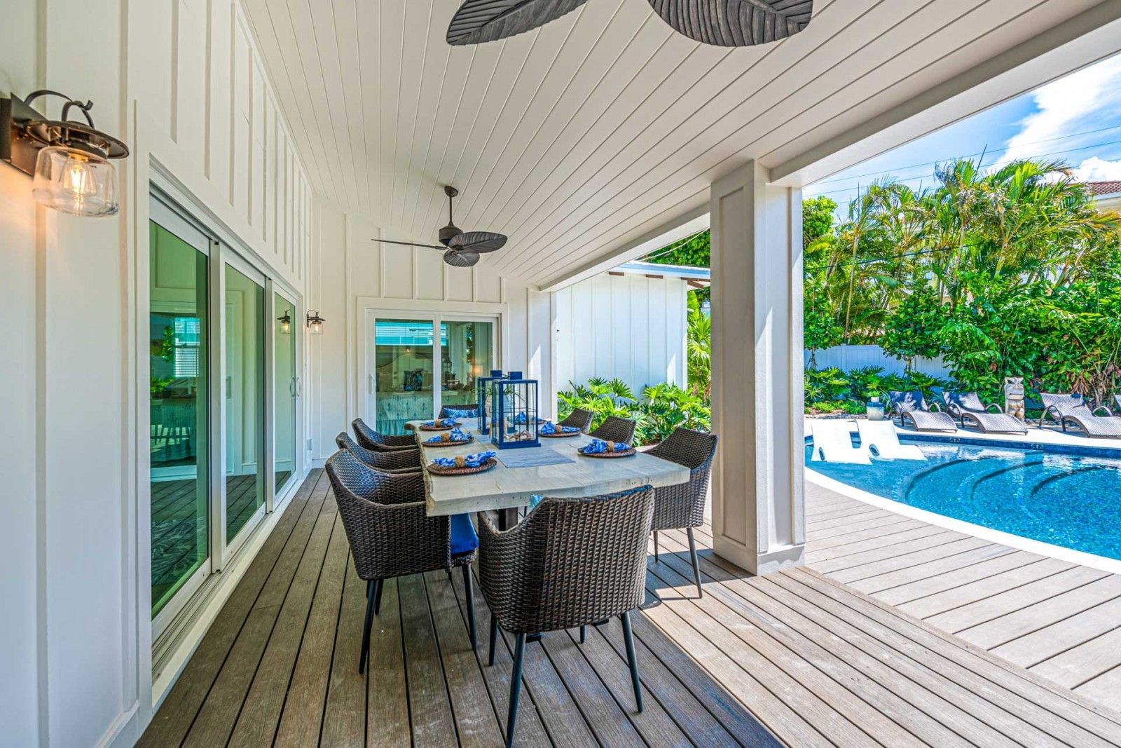 A large patio with a table and chairs next to a pool.