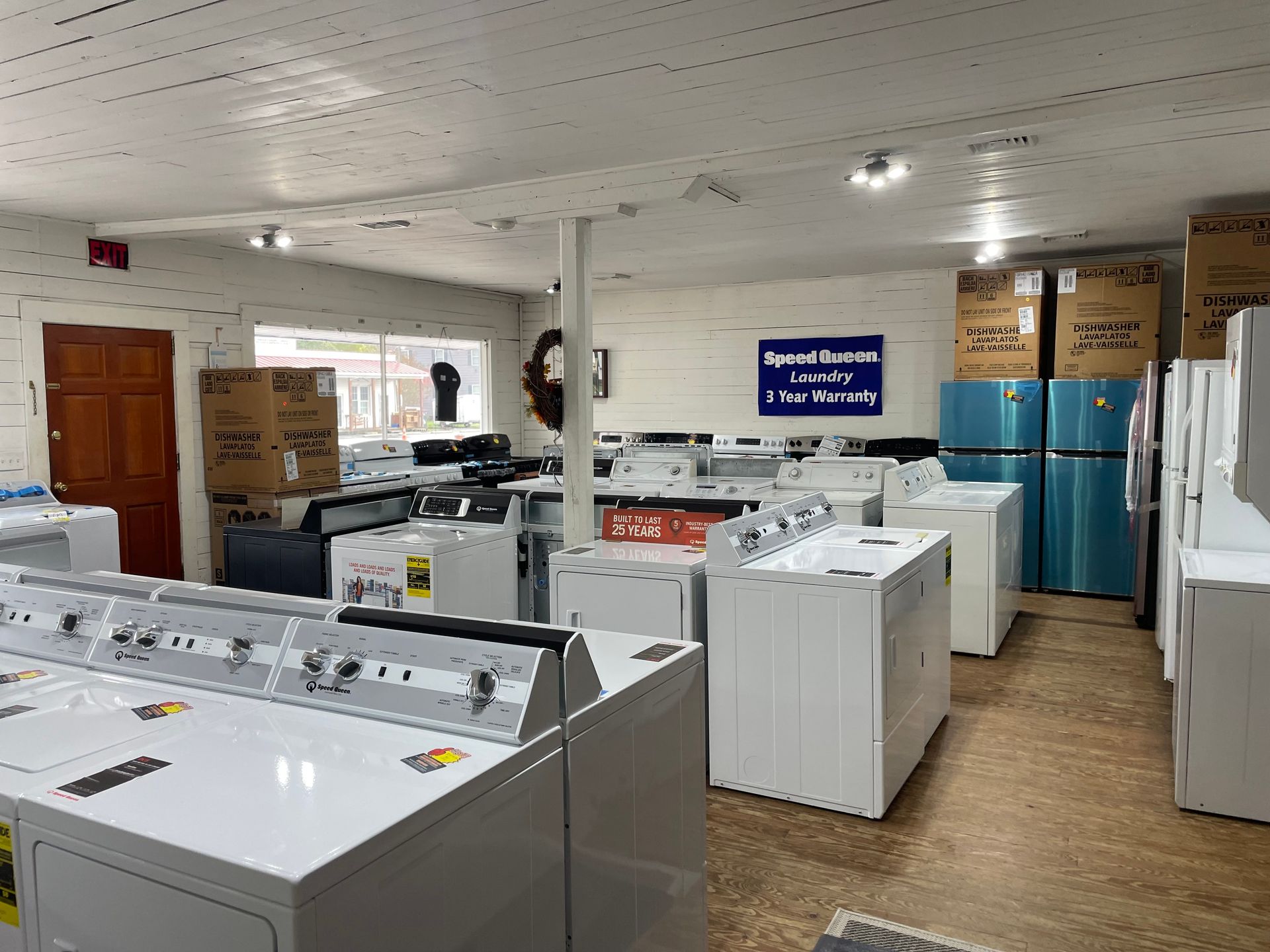 Interior of an appliance store, showcasing white washing machines and refrigerators.