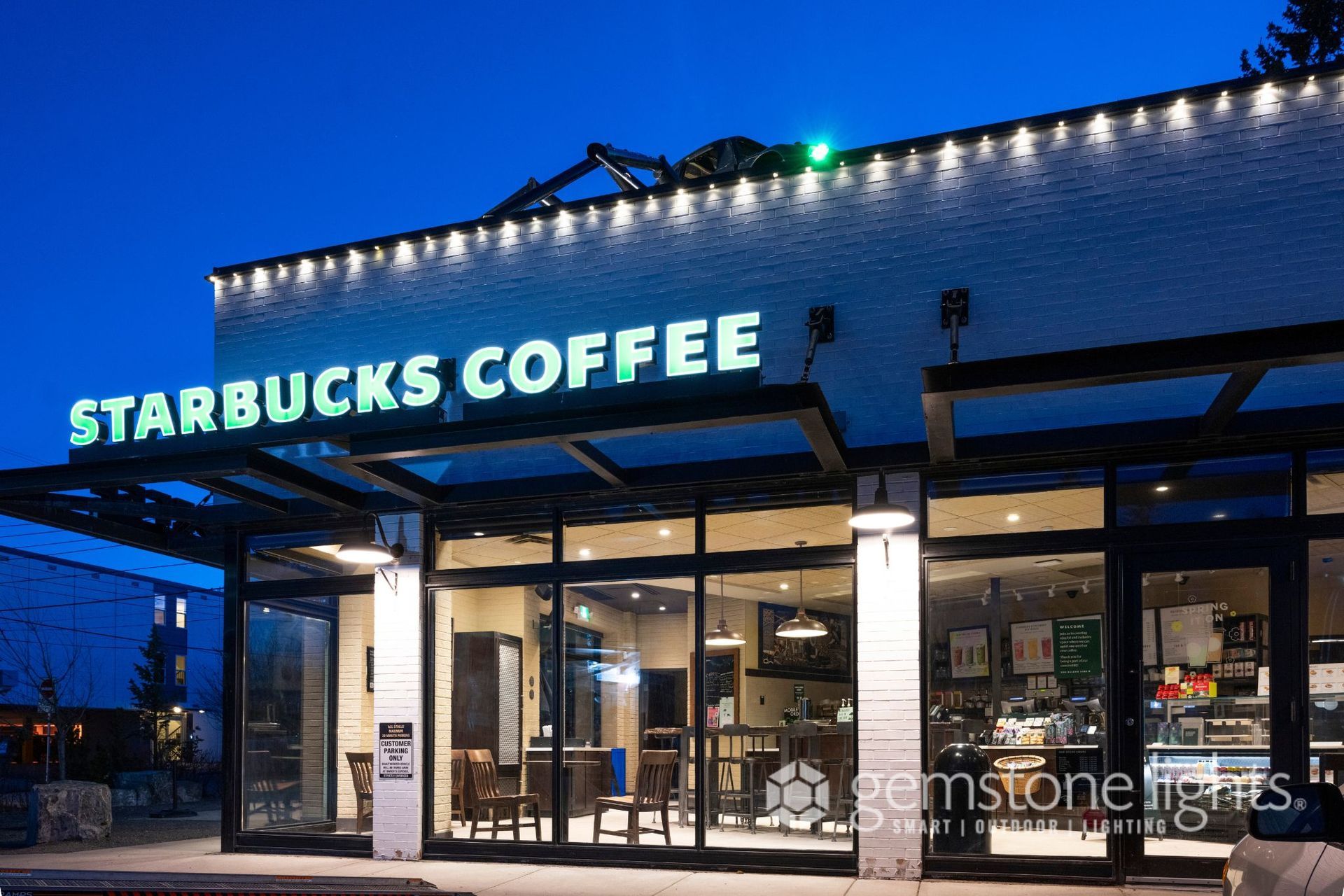 A starbucks coffee shop is lit up at night